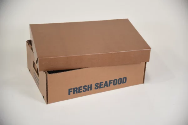 A close-up photo of a cardboard box filled with fresh seafood on a white background. The box has the words "FRESH SEAFOOD" printed on the side.