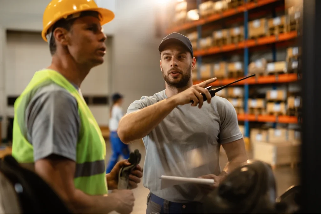 Two warehouse workers discussing operations