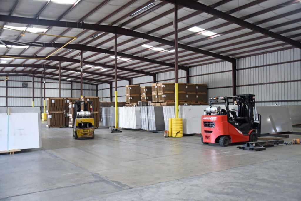 Warehouse interior with forklifts moving materials, emphasizing the logistics and handling capabilities of SCHC in their distribution solutions.